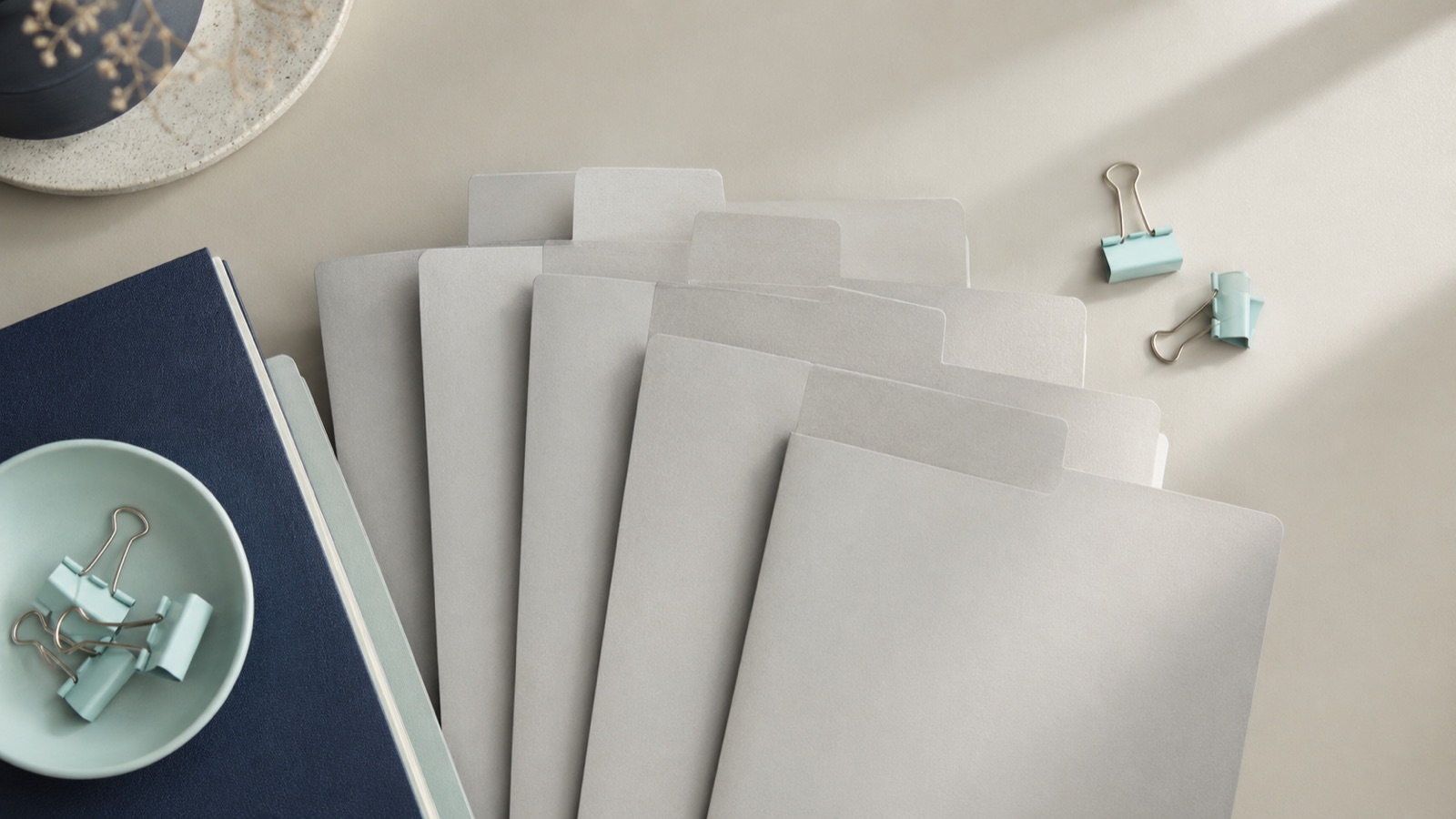 A fanned row of tabbed document folders on a desk