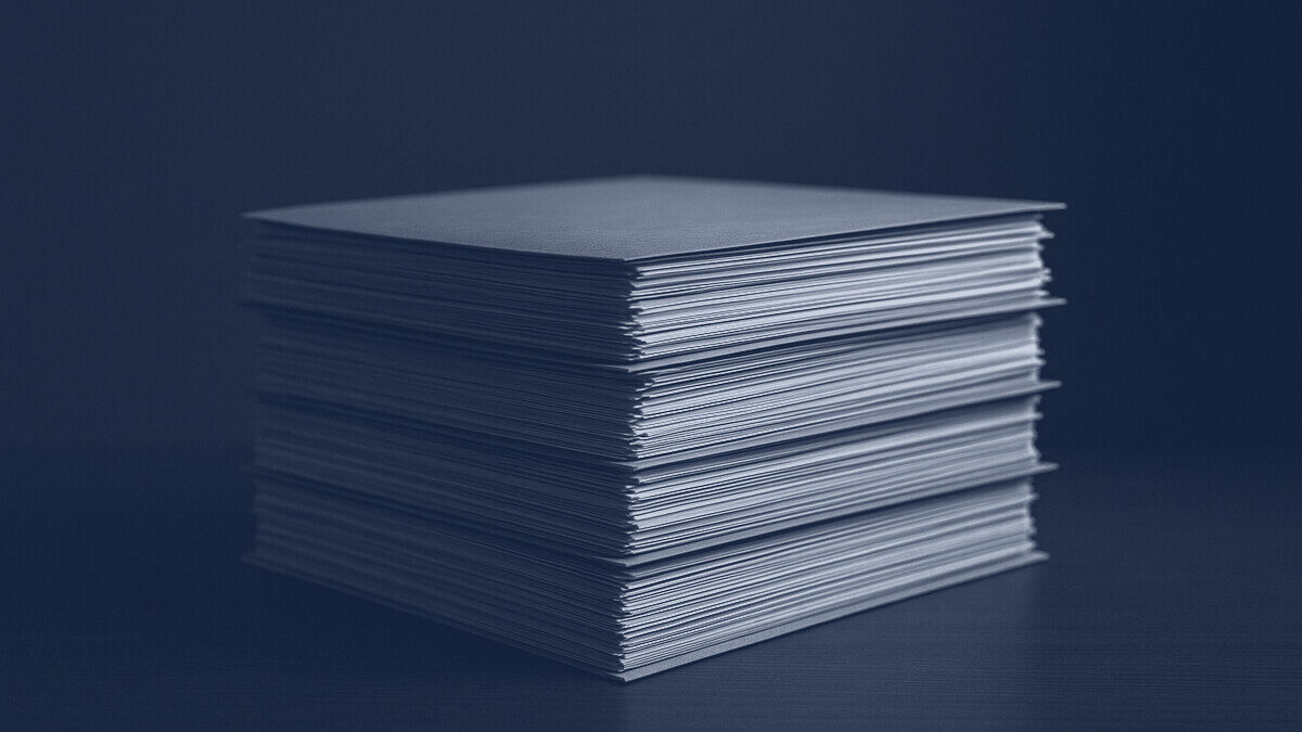 A stack of paper files squared on a desk