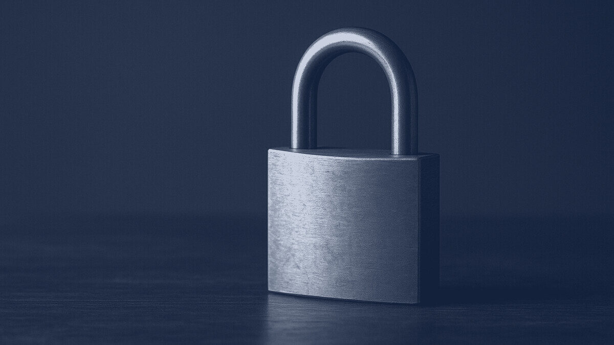 A brass padlock on dark wood