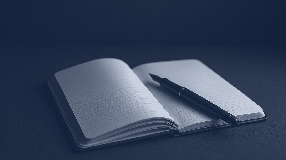 An open notebook with a fountain pen
