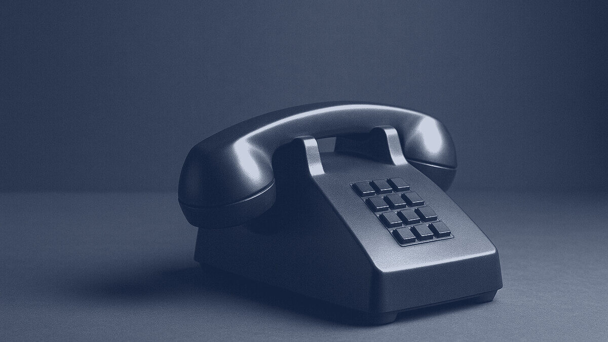 A classic desk telephone handset resting in its cradle
